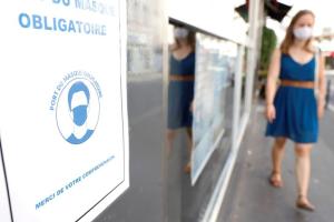 Jeune femme avançant masquée dans la rue et pannea "masque obligatoire"