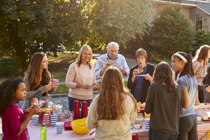 Voisins partageant un repas autour d'une table dans la rue