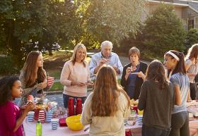 Voisins partageant un repas autour d'une table dans la rue